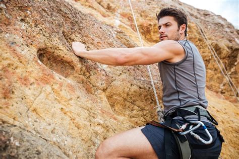 Young Man Climbing A Steep Wall In Mountain Stock Image Image Of