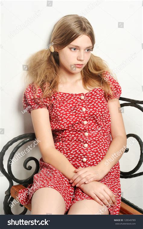 Sad Innocent Teen Girl Sitting On The Iron Bench Isolated On White