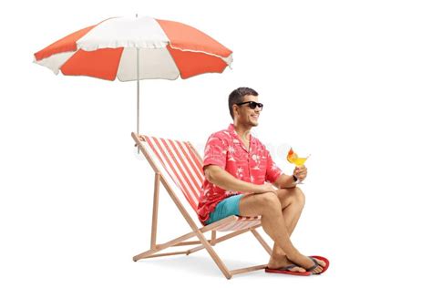 Homem Sentado Numa Cadeira De Praia Com Um Cocktail Debaixo De Um Guarda Chuva Imagem De Stock
