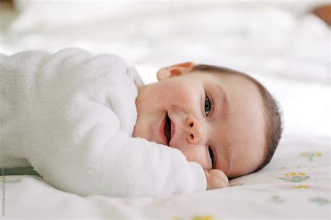 Smiling Baby Lying Down On The Bed Del Colaborador De Stocksy Acalu