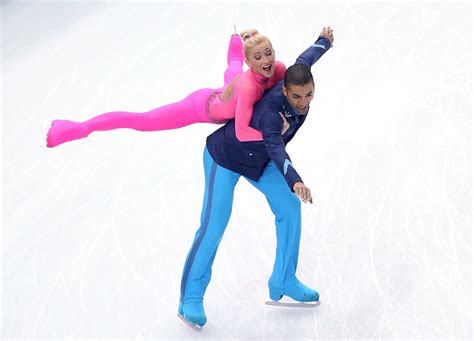 A Man And Woman Skating On An Ice Rink