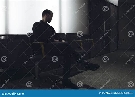 Silhouette Of Handsome Man Sitting Alone Backlit In Dark Subway