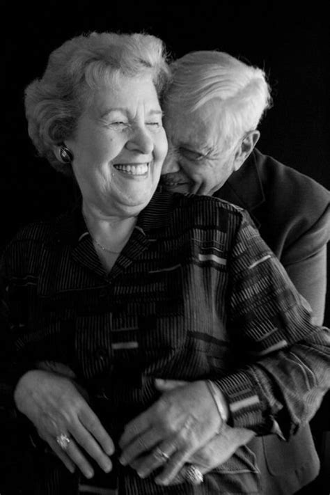 An Older Woman Hugging Her Younger Lady On The Back Of A Chair In Black And White