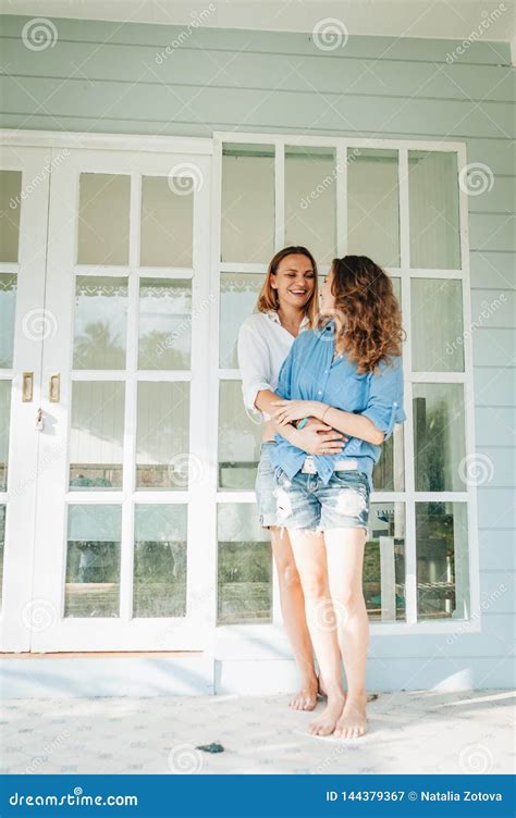 position lesbienne heureuse de couples sur la terrasse leur maison de campagne image stock