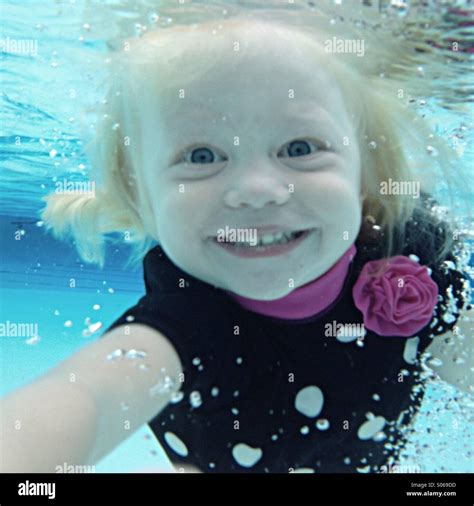 Young Girl Smiling As She Swims Towards Camera Underwater Stock Photo
