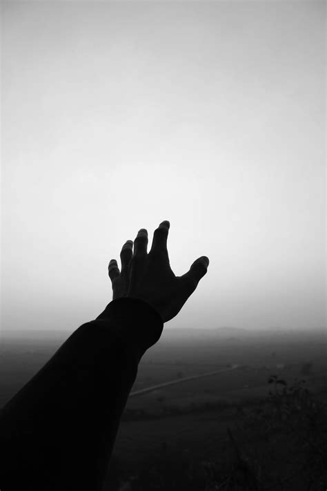 Grayscale Photo Of Persons Hand Reaching For The Sky · Free Stock Photo
