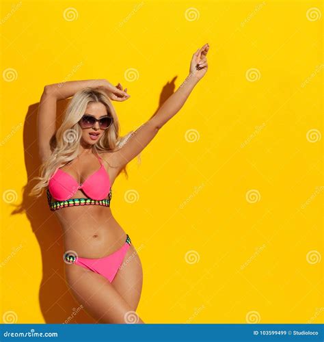 De Sexy Blonde Vrouw In Roze Bikini Geniet Van Het Zonlicht Stock