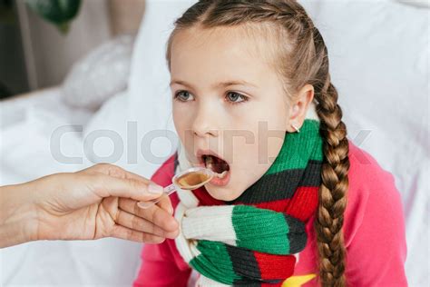 Mom Giving Syrup To Ill Daughter With Scarf In Bed Stock Image Colourbox