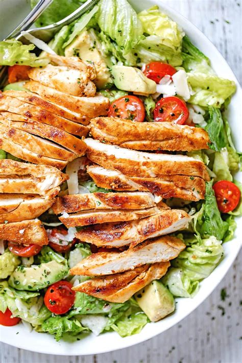 A Salad With Chicken Lettuce And Tomatoes