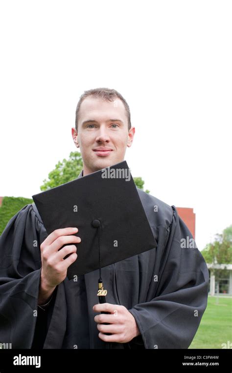 Caucasian Graduate Holding Graduation Cap Stock Photo Alamy