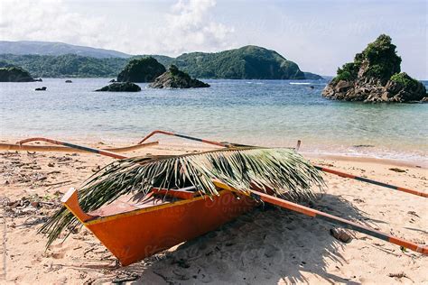 Traditional Asian Boat Covered With Palm Leaf On A Tropical Beach By Stocksy Contributor