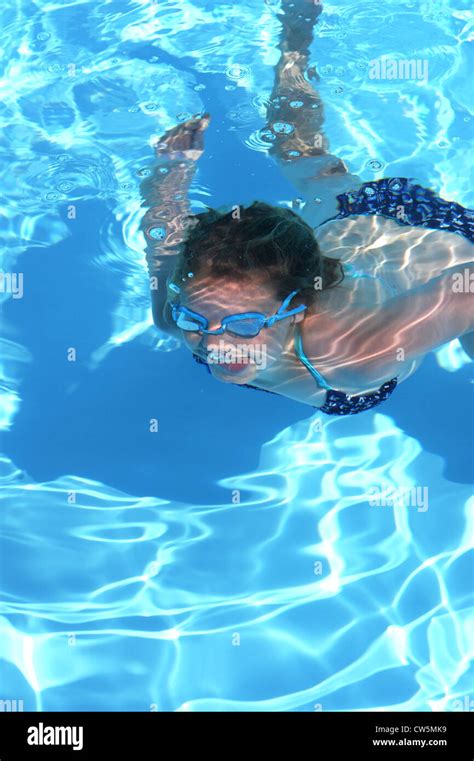 Young Girl 12 Years Old Swimming Underwater In Outdoor Swimming Pool On