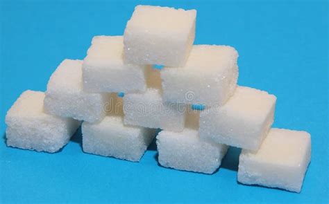 On A Blue Background Lump Sugar Is Folded In The Shape Of A House Stock