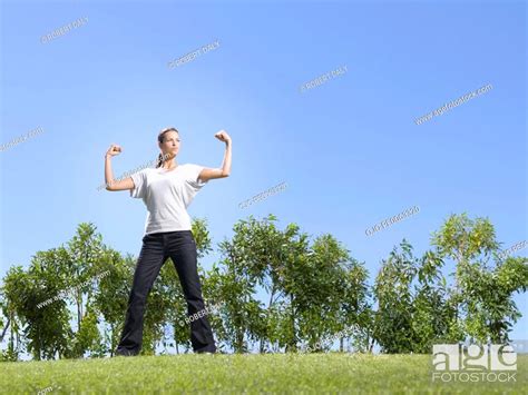 Woman Flexing Muscles In Field Stock Photo Picture And Royalty Free