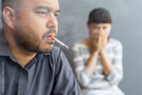 Husband Smoking Cigarette And Wife Choking Of Smoke Man Smoking Cigarette And Woman Is Covering
