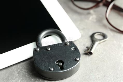 Metal Lock And Tablet On Grey Table Closeup Protection From Cyber