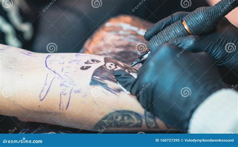 Professional Tattoo Artist Makes A Tattoo On A Young Manâ€™s Hand