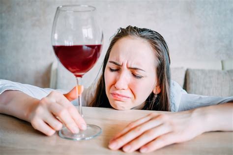 premium photo drunk girl drinks wine and weeps over the table