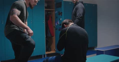 medium shot of two men bullying their peer in locker room stock video footage dissolve