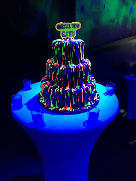A Multi Tiered Cake With Neon Lights On The Top And Bottom Is Lit Up