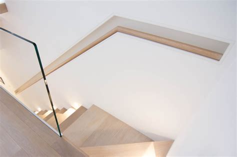 A Minimalist Floating Staircase With Oak Clad Treads And Glass Wall
