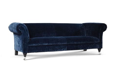 A Blue Velvet Sofa With Metal Legs And Arms On An Isolated White