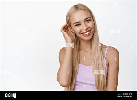 cute smiling girl tuck hair behind ear and looking happy at camera concept of women skin care