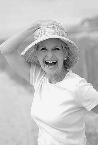 An Older Woman Wearing A Straw Hat And Posing For The Camera With Her