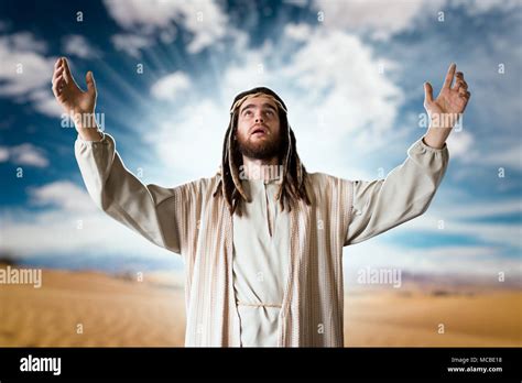 Jesus Praying With His Hands Up Against Cloudy Sky Stock Photo Alamy