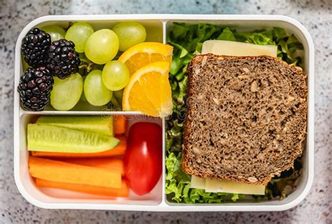 Green School Lunch Box With Sandwich Fresh Fruits Cucumber And Carrot