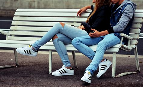 wallpaper id 237970 a man puts his hand around a woman in jeans sitting on a white bench