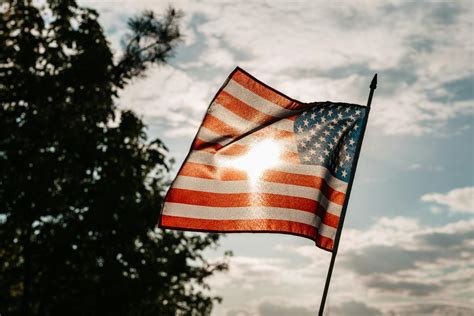 American Flag On Independence Day Under Cloudy Sky · Free Stock Photo