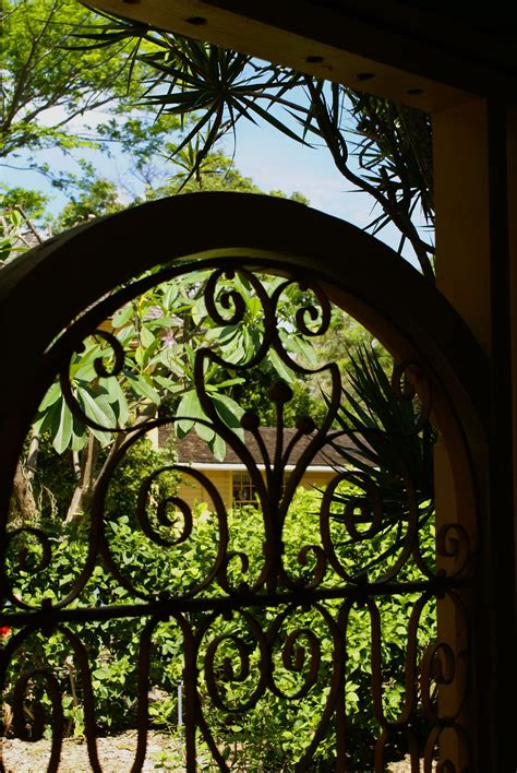 One widely adapted form is a slatted gate with a large circular window and an overhead trellis structure. Garden gate | Garden gates, Garden arch, Secret garden