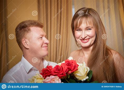 An Adult Couple Of Newlyweds In Beautiful Dress In A Hotel Room After