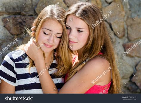Teenage Girl Comforting Crying Friend With Warm Hug Stock Photo