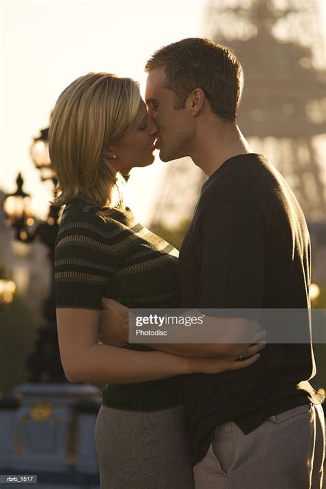 A Young Attractive Caucasian Couple Embrace And Kiss At The Eiffel