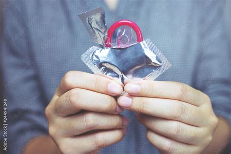 condoms ready to use in female hand give condom safe sex concept on the bed prevent infection