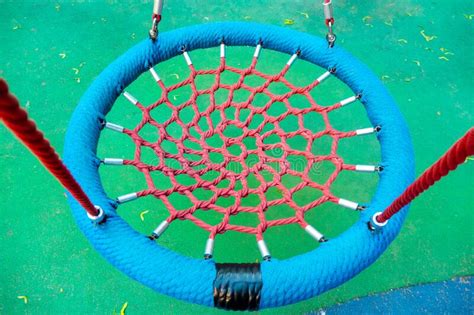 Round Swing Seat Made Of Mesh In Playground Empty Blue Rope Web Nest