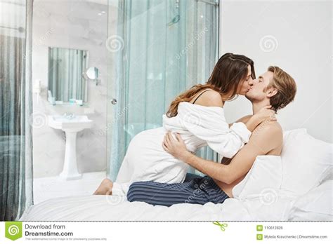 Two Beautiful People In Love Kissing And Lying In Hotel Bedroom In