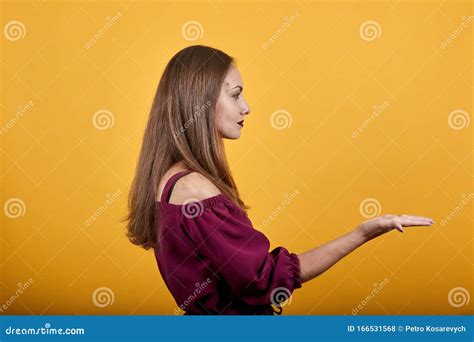 Young Woman Extending Hands To Side For Inviting To Come Stock