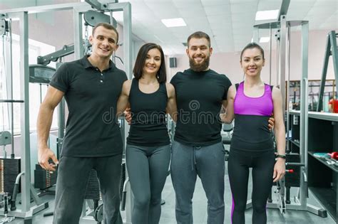 Group Of Young Smiling Sport People Embracing Together In Fitness Gym