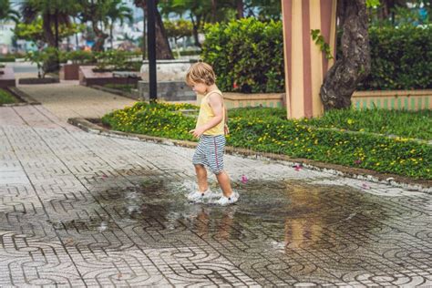 Little Boy Runs Through A Puddle Summer Outdoor Stock Image Image Of