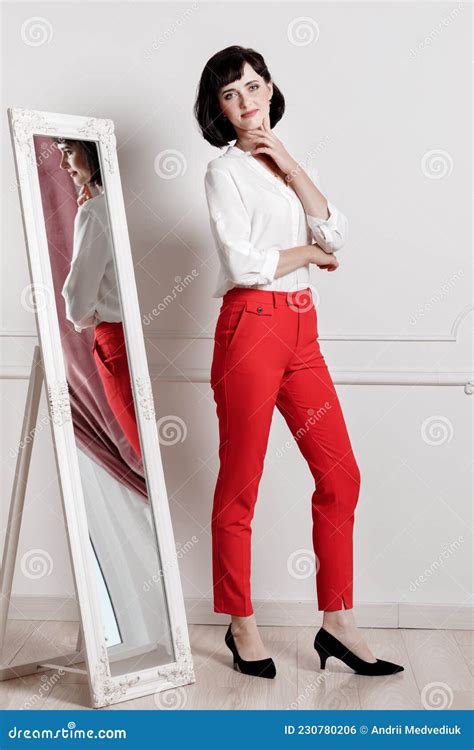 Full Length Photo Of A Beautiful Young Woman Standing Near The Mirror
