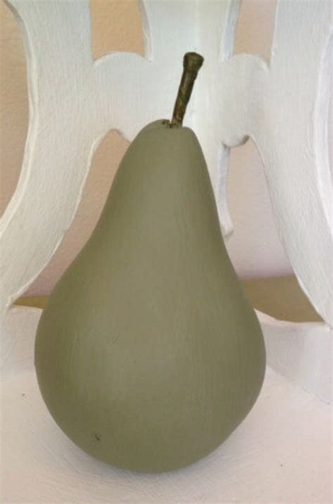 A Green Pear Sitting On Top Of A White Table