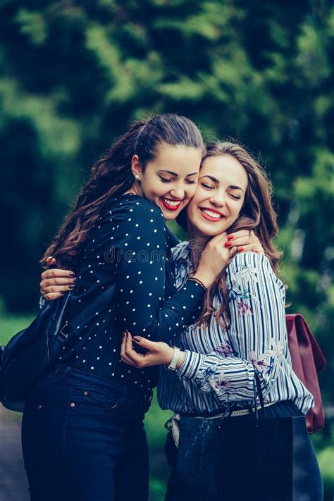 Dos Amigos Felices Emocionales De La Mujer Que Se Abrazan En El Parque