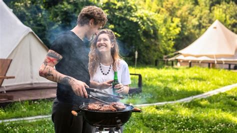 Premium Photo Young Couple Frying Meat On The Grill And Drinking Beer Laughing Greenery