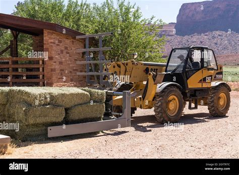 A Caterpillar Th580b Telescopic Forklift With A Hay Squeeze Attachment