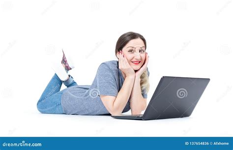 Happy Smiling Young Girl Lying With Laptop On The Floor Isolated On