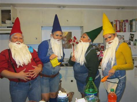 Three People Dressed As Gnomes Standing In A Kitchen With Bottles On