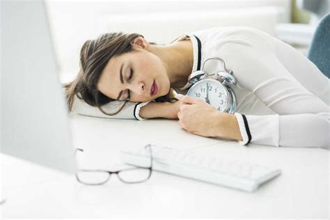Overworked Woman Sleeping On Desk In Office Stock Photo